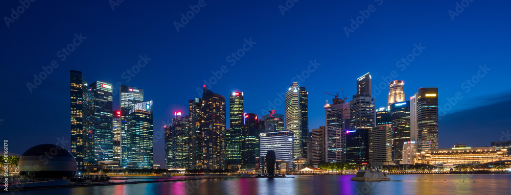Wide panorama image of Singapore skyscrapers at magic hour.