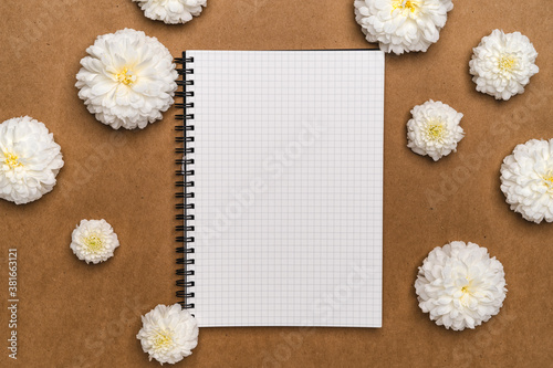 Notebooks and flowers- notebook and white flowers on brown paper