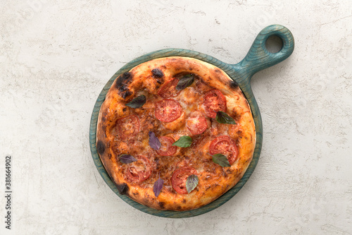 delicious pizza with tomatoes and basil on a wooden tray