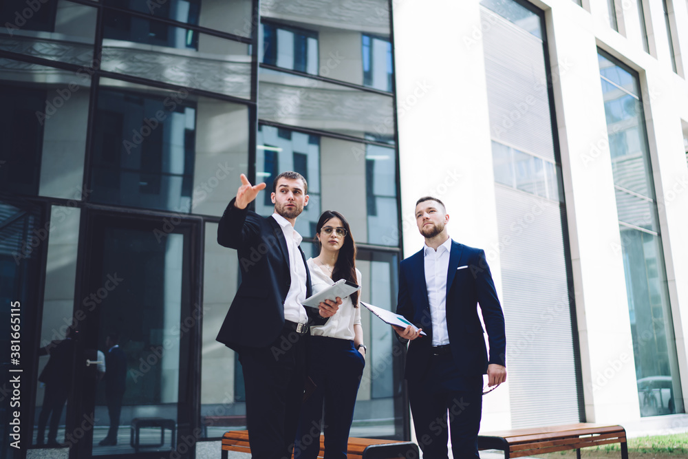 Business people discussing business issue while standing outside office Business people discussing business issue while standing outside office