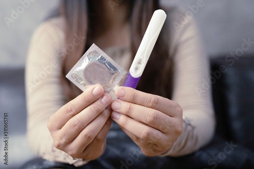 Women holding birth control pills with pregnancy test kits.