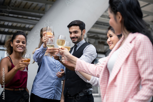 Group of business people celebrate by drinking wine.