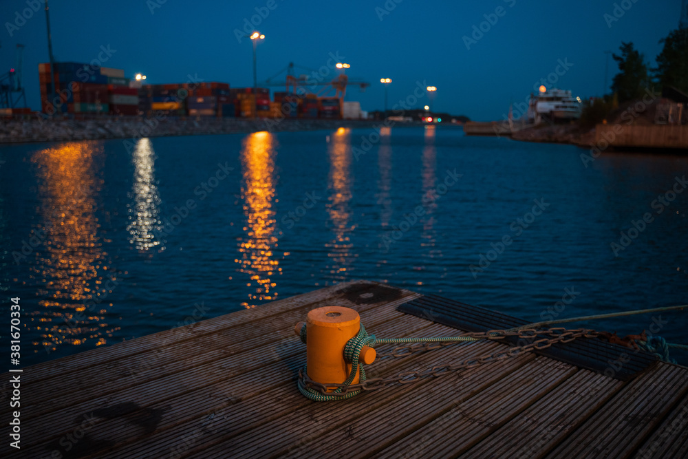 Bollard at harbor with water in the background