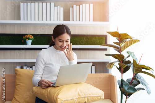 Asian young Businesswoman working laptop computer on wood desk in Home