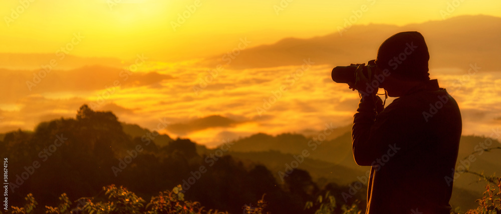 Silhouette professional man photographer holding camera for take a photo the mountain  field during mist sunrise nature.  