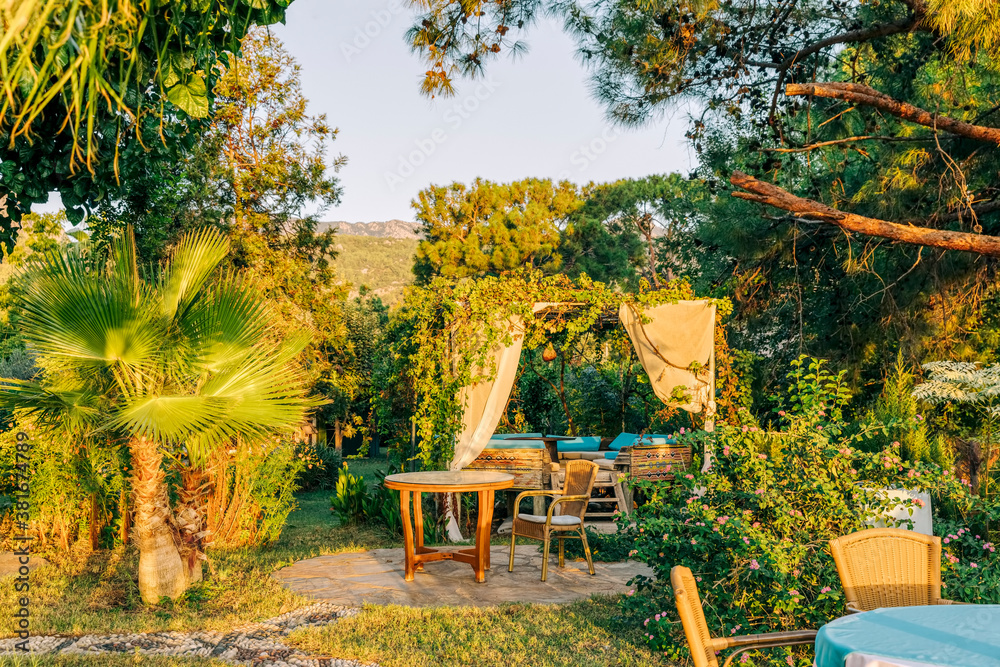 Obraz premium Garden restaurant with umbrella and palm tree