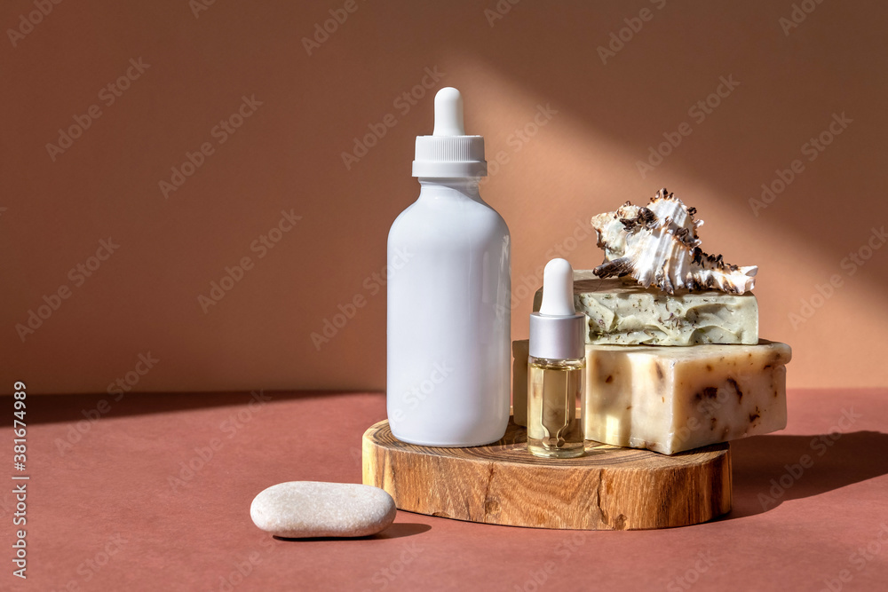 Glass bottles essential oils, beauty and body care product concept on trendy stands or podiums. Presentation mockup, copy space. Sun light and shadows.