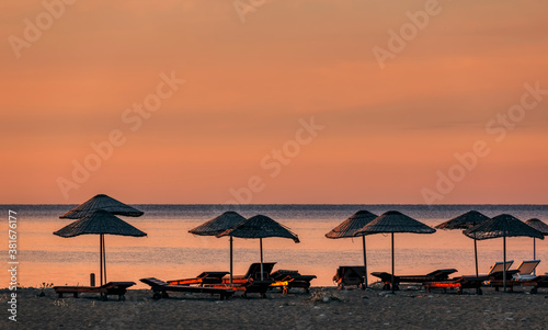 Beach umbrellas at sunrise © amelie