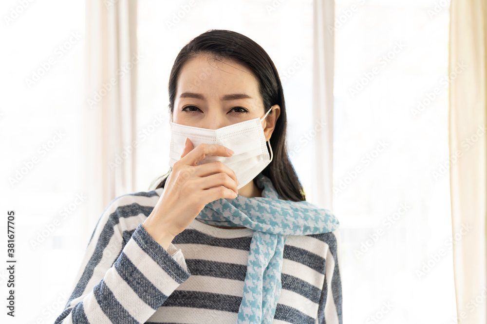 Young Asian woman sneezing or coughing while wearing protective medical face mask. Woman have a fever, sick, unwell. Health and medical concept. Young Asian woman sneezing or coughing while wearing protective medical face mask. Woman have a fever, sick, unwell. Health and medical concept.