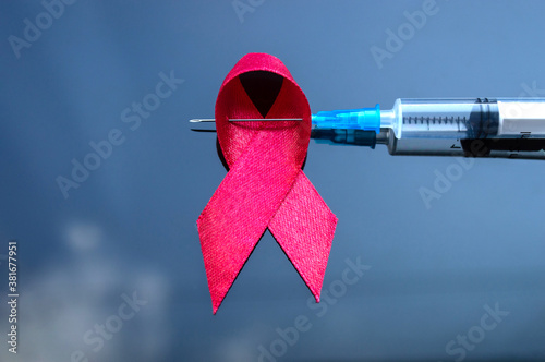 A sign of the fight against AIDS pierced with a syringe. World AIDS Day. photo