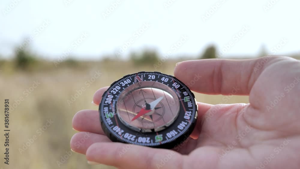 Traveler's hand holds a compass of nature background. Traveler's hand holds a compass of nature background.