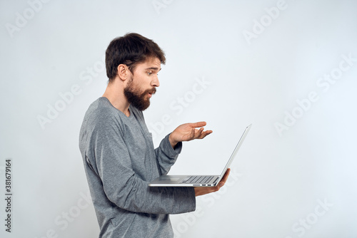 A man holding a laptop internet communication lifestyle technology light background studio © SHOTPRIME STUDIO