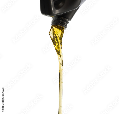 Pouring fresh automotive engine oil (lubricating oil, yellow liquid oil) into a motor car isolated on white background. Change new oil. Maintenance, service, and energy fuel concept. .