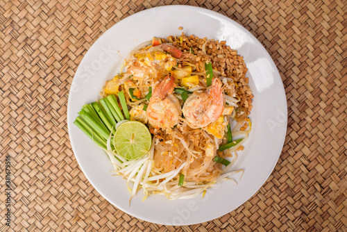 Top view of Thai traditional food Pad Thai Noodles with shrimp in dish on wooden table