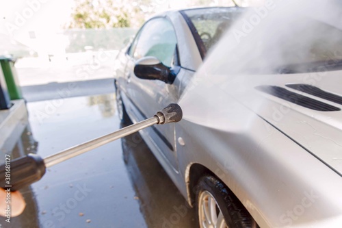 Washing car with pressure washer at self-service car wash station © mitarart