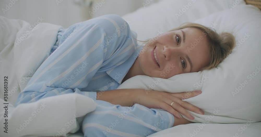 Woman wakes up raise stretches hands in bed feels healthy. The girl lies in bed, wakes up and sweetly stretches. Woman wakes up raise stretches hands in bed feels healthy. The girl lies in bed, wakes up and sweetly stretches.