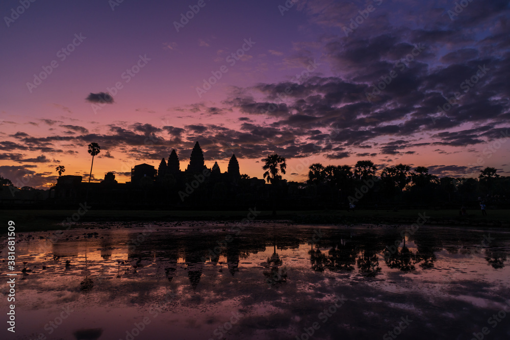 Naklejka premium The silhouette of Angkor Wat temple, reflected on the water surface at the entrance of the temple, Siem Reap, Cambodia.