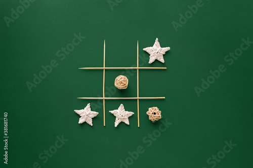 New Year tic tac toe game isolated on green background with zero waste Christmas decorations. Eco friendly new year concept. Reusable sustainable recycled decor. Flat lay, top view.