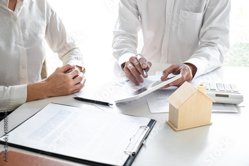 Real estate broker agent presenting and consult to customer to decision making sign insurance form agreement, home model, concerning mortgage loan offer for and house insurance