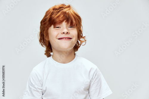 Smiling redhead boy looking forward cropped view of white t-shirt