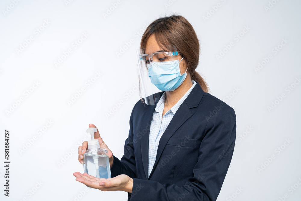 Businesswoman with face mask and Face shield using hand sanitizer while cleaning her hands in the office. Working from home, Woman wearing protective mask. Corona virus protection. Businesswoman with face mask and Face shield using hand sanitizer while cleaning her hands in the office. Working from home, Woman wearing protective mask. Corona virus protection.