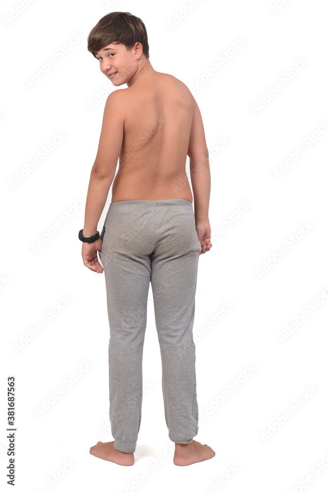 Fototapeta premium rear view of a teen boy shirtless on white background, looking at camera