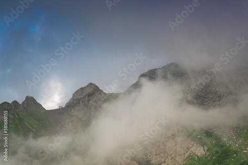 Cloudy slopes and mountain peaks, beautiful landscape © Vladislav