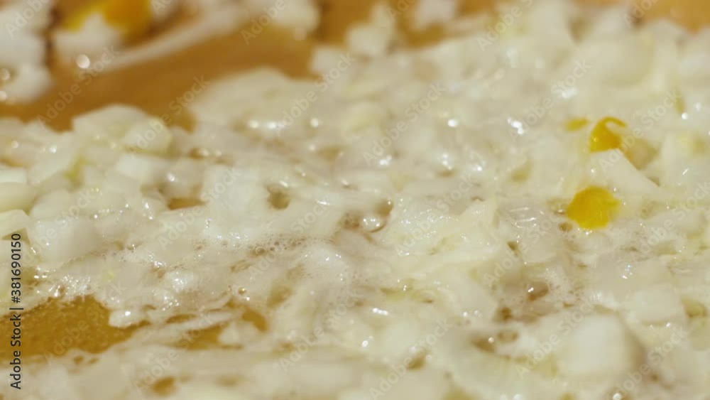 Close up diced onions sizzling in pan in slow motion Close up diced onions sizzling in pan in slow motion
