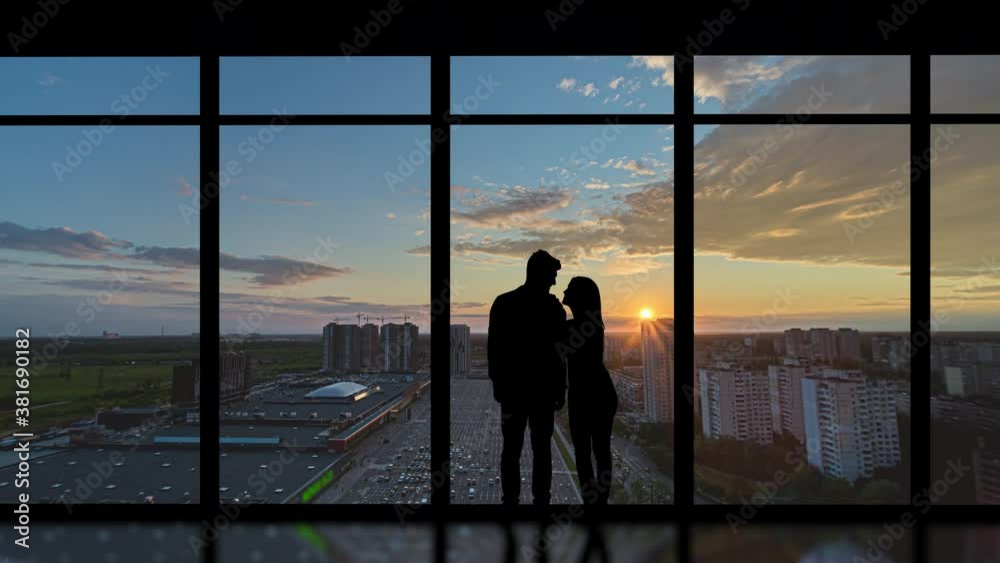 The romantic couple stand near the big windows on the city background. time lapse The romantic couple stand near the big windows on the city background. time lapse