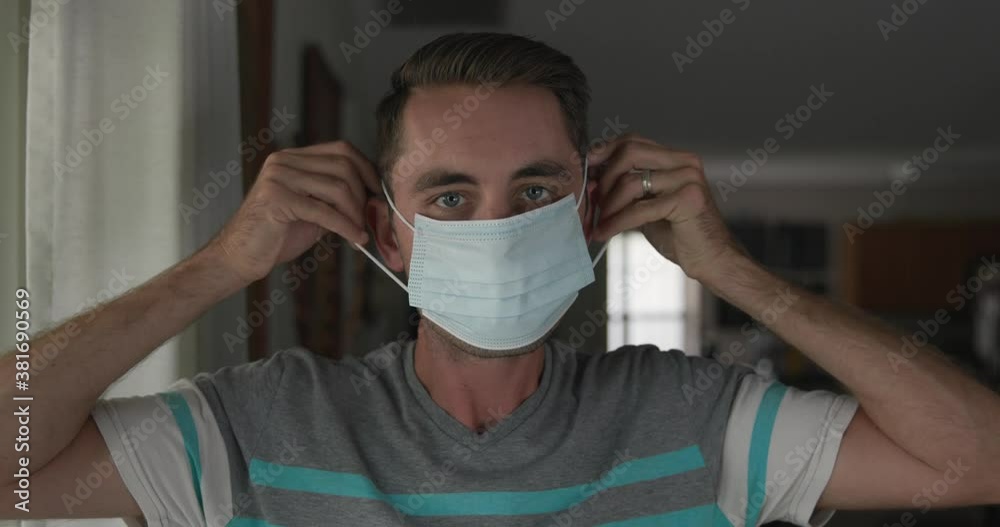 Young man putting on covid pandemic mask Young man putting on covid pandemic mask