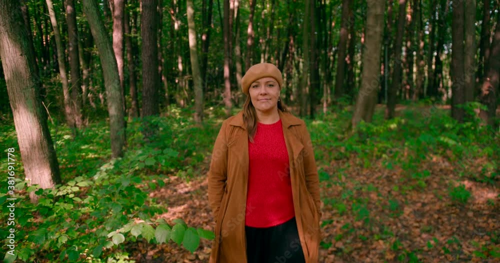 Caucasian women with an overcoat and hat walking in the forest trail. Caucasian women with an overcoat and hat walking in the forest trail.