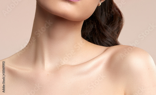 Fotografia Women's neck and shoulders skincare brown hair on a nude background