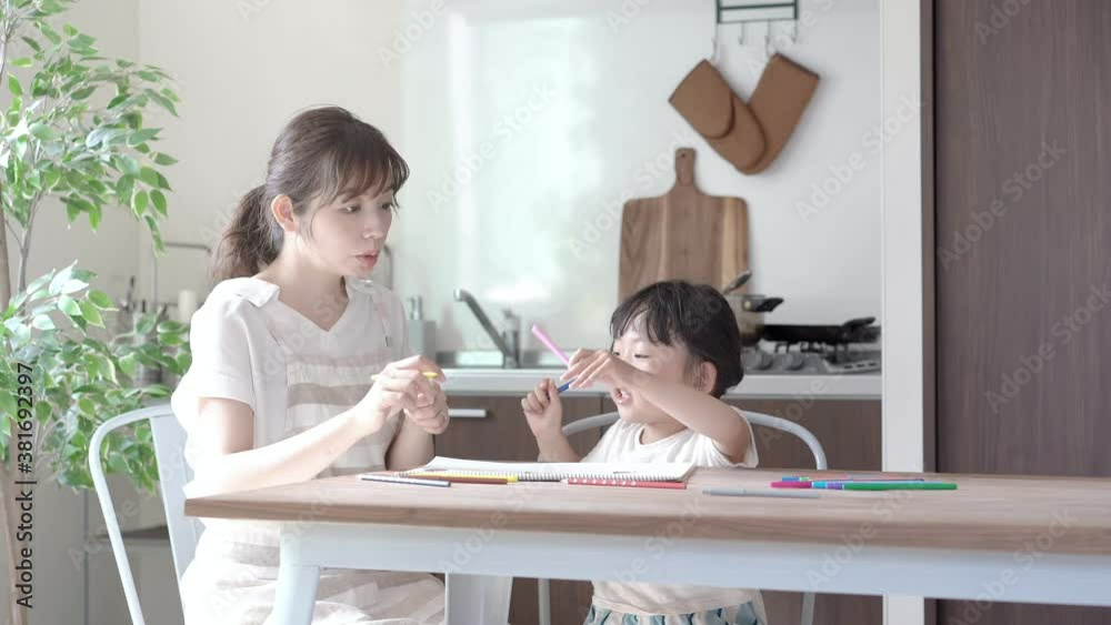 ダイニングテーブルでお絵かきをするお母さんと娘
