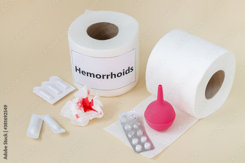 Hemorrhoids treatment concept. Toilet paper with blood next to enema