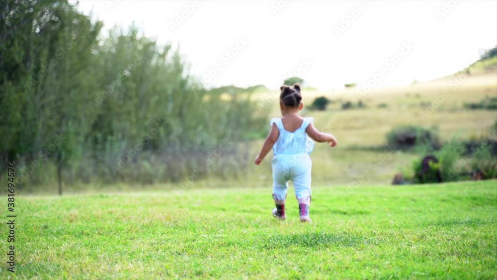 Two year old South African girl running away from camera Two year old South African girl running away from camera