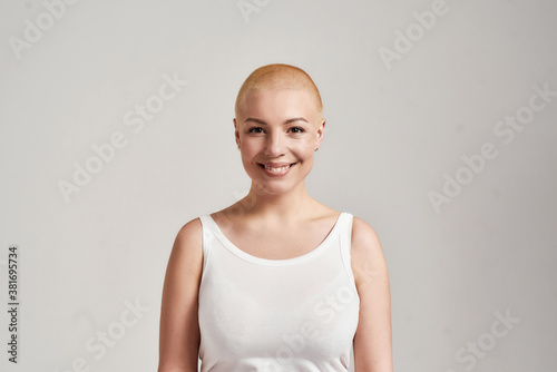 Фотография Portrait of a beautiful young caucasian woman with shaved head wearing white shi