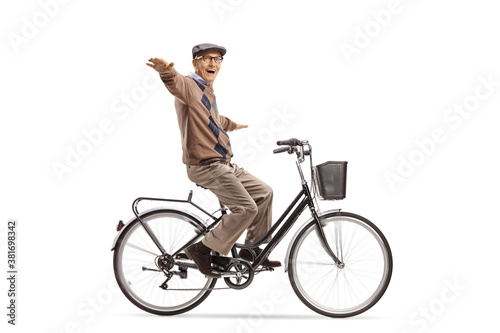 Happy elderly man riding a bicycle and spreading arms