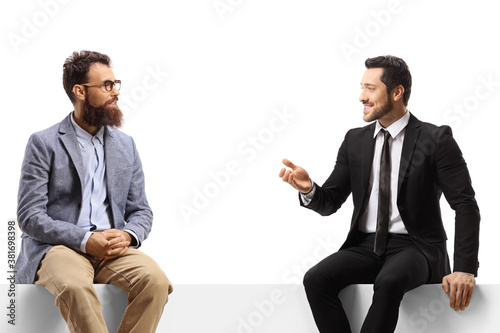Men sitting on a panel and having a conversation