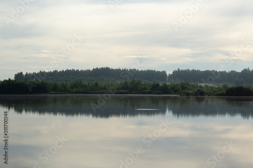 Forest on the shore of an endless lake. Morning on the lake. © Ксения Ульянова