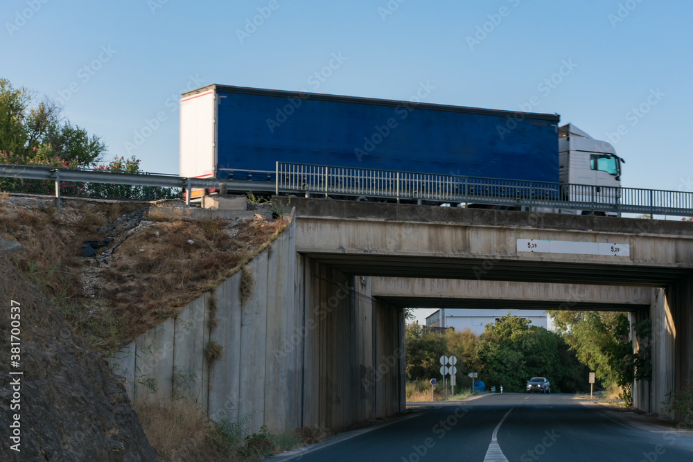 Obraz premium Truck driving over a bridge with a road underneath