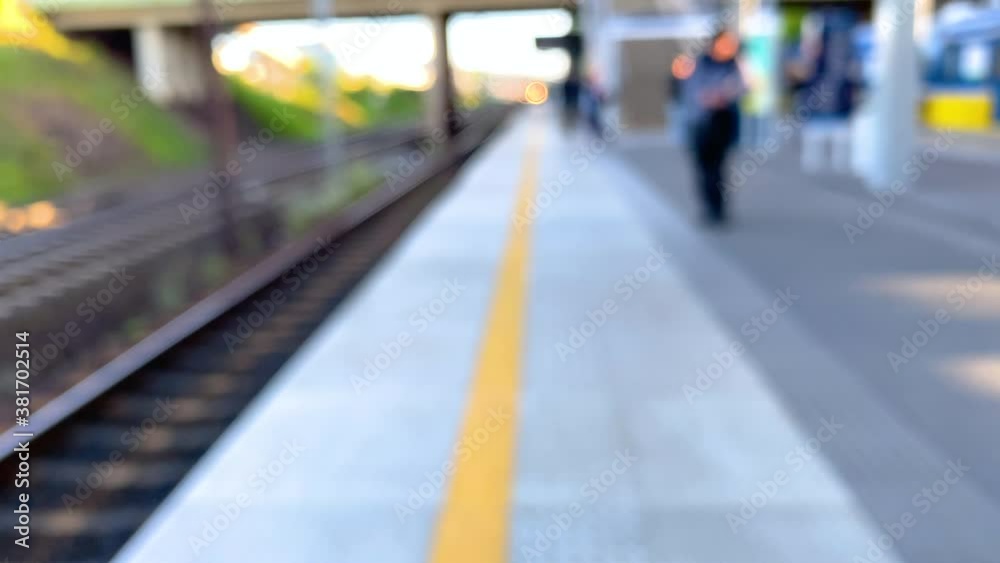 Passengers wait out of focus on quiet a Train Station Platform, defocused in Slow motion / High Frame Rate Passengers wait out of focus on quiet a Train Station Platform, defocused in Slow motion / High Frame Rate