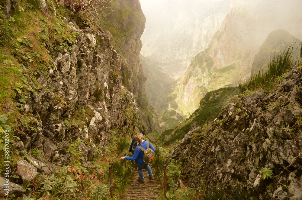 Obraz premium Climbing to the dramatic peak of Pico Ruivo mountain on the ridge of Madeira Island, Portugal