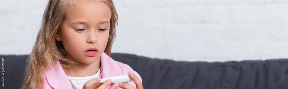 Panoramic shot of child looking at thermometer at home Panoramic shot of child looking at thermometer at home
