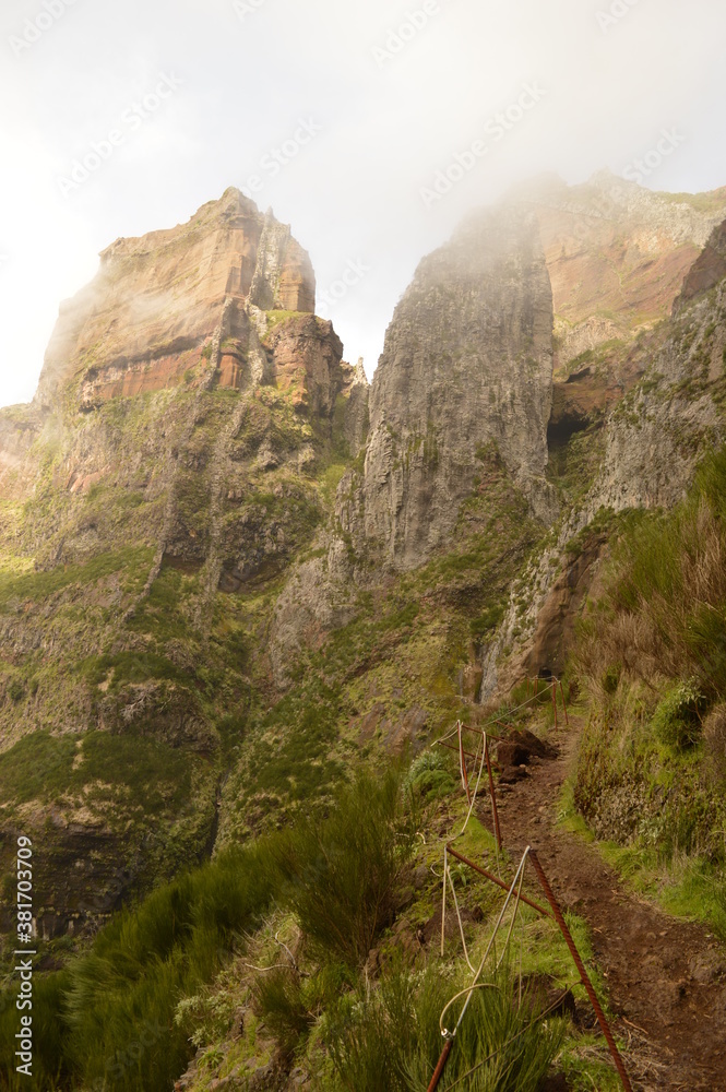 Obraz premium Climbing to the dramatic peak of Pico Ruivo mountain on the ridge of Madeira Island, Portugal