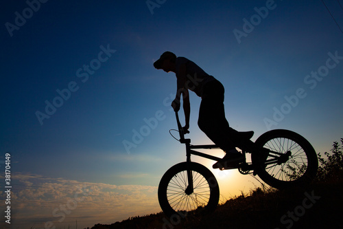 Silhouette of a cyclist against the blue sky.