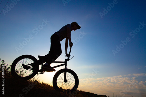Silhouette of a cyclist against the blue sky.