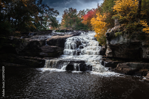 Brilliant fall foliage surrounds the beautiful cascading Shohola Falls in the Pennsylvania Poconos
