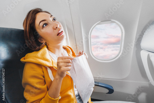 Obraz na plátne An Asian female traveler suffers from an acute attack of nausea during turbulence on a plane