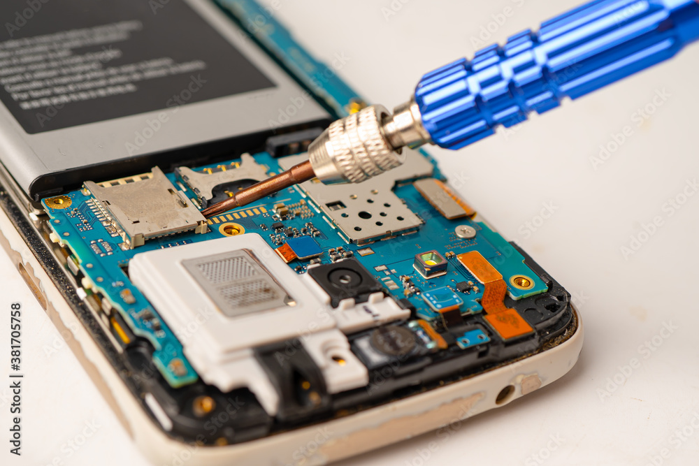 Technician repairing inside of mobile phone by soldering iron. Integrated Circuit. the concept of data, hardware, technology. Technician repairing inside of mobile phone by soldering iron. Integrated Circuit. the concept of data, hardware, technology.