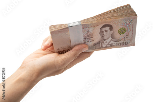 Fotografija Holding stack of Thai baht banknotes on white background with clipping path  business saving finance investment concept